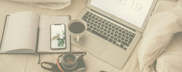 blog niche list - laptop and camera and coffee on bed